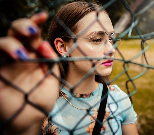 Photo Of Woman Holding Chain Link Fence