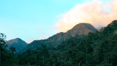 Free Lush green mountains under a colorful sky during sunrise, perfect for nature and tranquility themes. Stock Photo