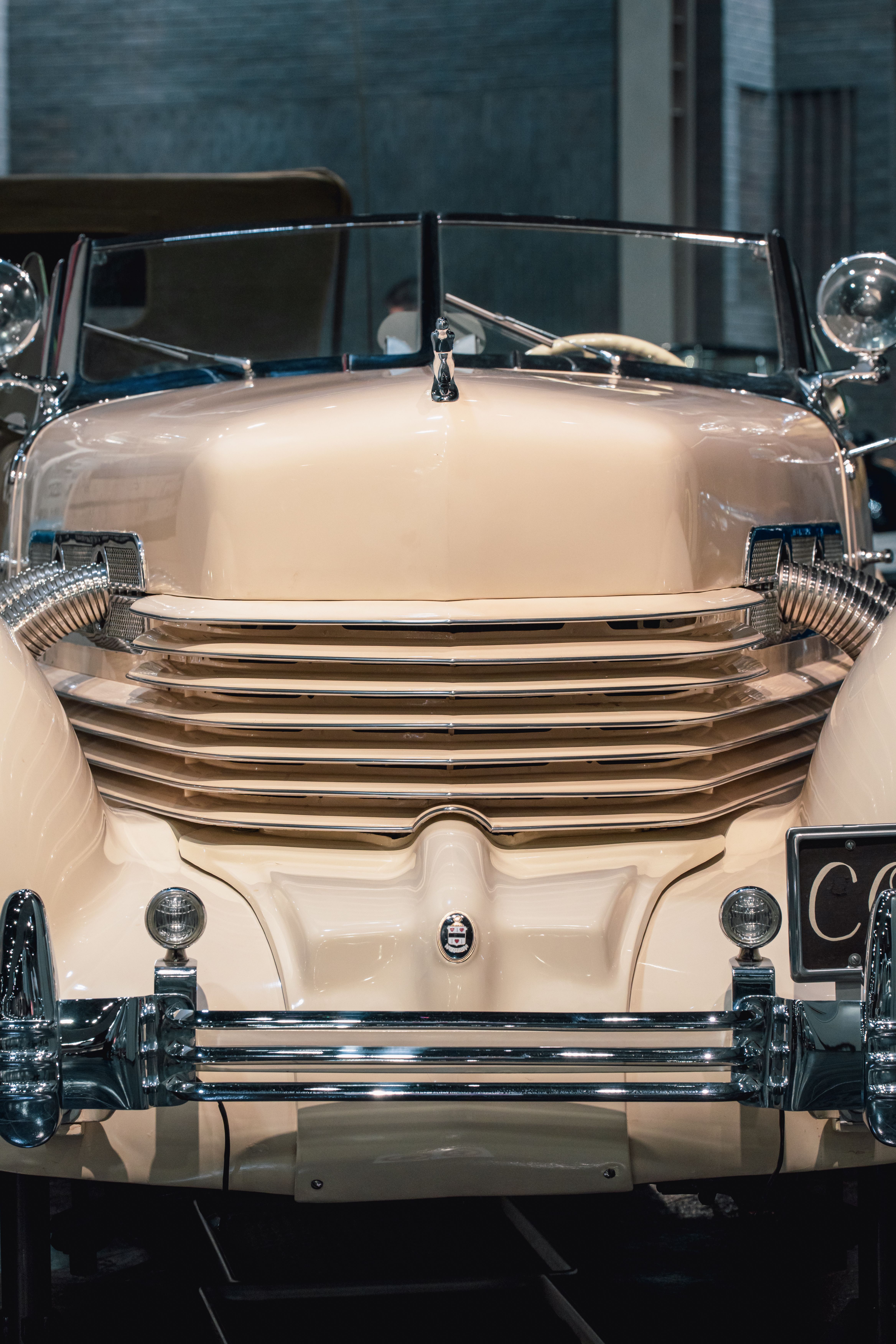 Close-up of a vintage car's front grill, showcasing timeless design in a well-lit indoor setting.