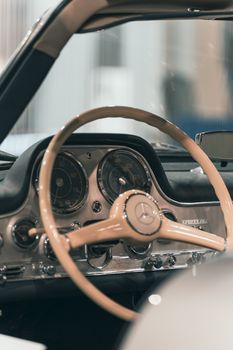 Close-up view of a vintage car's interior showcasing a classic dashboard and steering wheel.