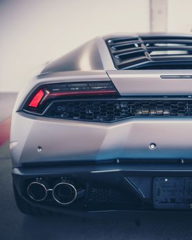 Close-up of a stylish sports car rear, featuring sleek design and dual exhausts.