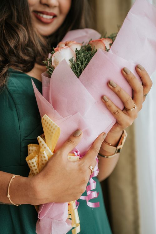 Free Close-up of woman holding a pink bouquet, smiling indoors. Stock Photo