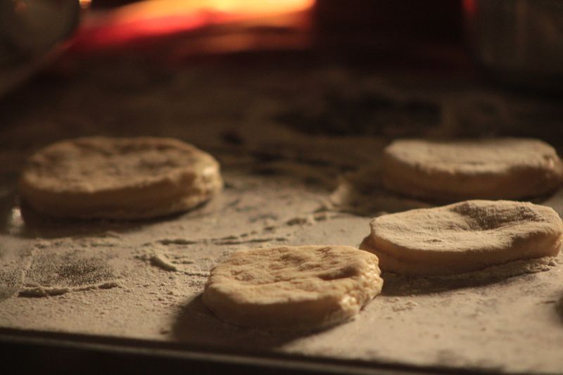 Close-up view of biscuit dough pieces on a flour-dusted surface, ready to bake.