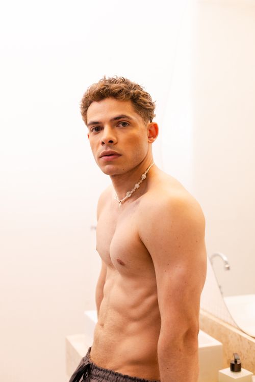 Free Shirtless young man posing confidently indoors, showcasing modern style. Stock Photo