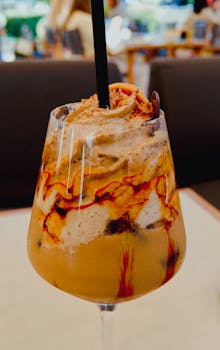 A tempting iced coffee with whipped cream and caramel in a cafe setting.