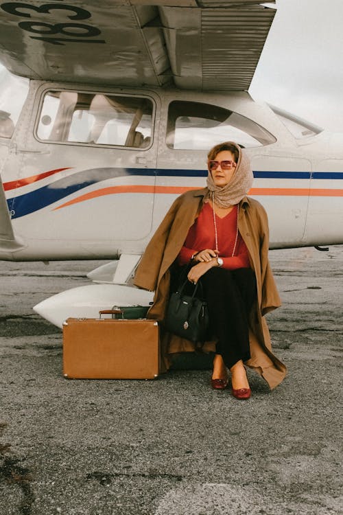 Photo of Woman Sitting Near Airplane