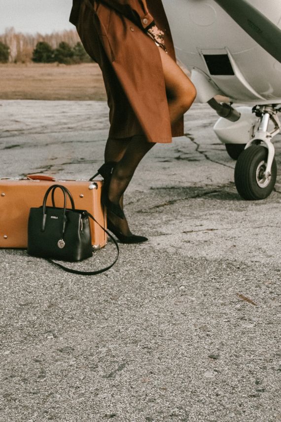 Elegant woman traveling with luggage near an airplane