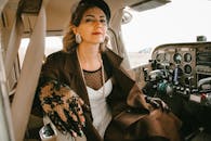 一位身着时尚服装的优雅女性，在飞机驾驶舱内自信地摆着姿势