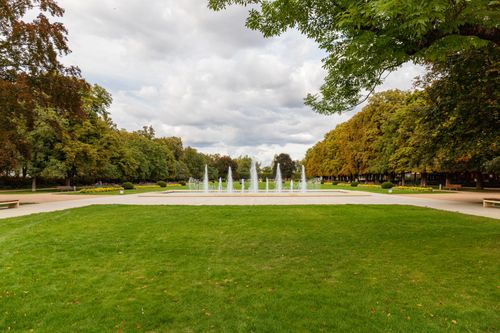 Free Tranquil scene of a public fountain surrounded by lush greenery in Poděbrady, Czech Republic. Stock Photo