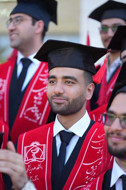 Free Happy graduates in caps and gowns celebrating their achievement outdoors. Stock Photo