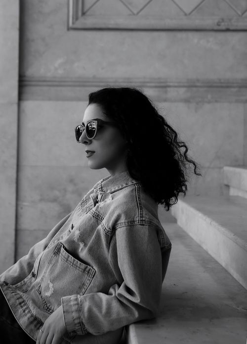 Free Chic portrait of a woman in sunglasses against a textured wall, portraying modern fashion with a cool demeanor. Stock Photo