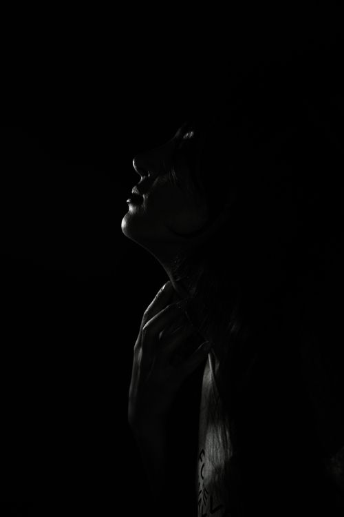 Free Silhouetted woman in artistic black and white portrait with dramatic lighting. Stock Photo