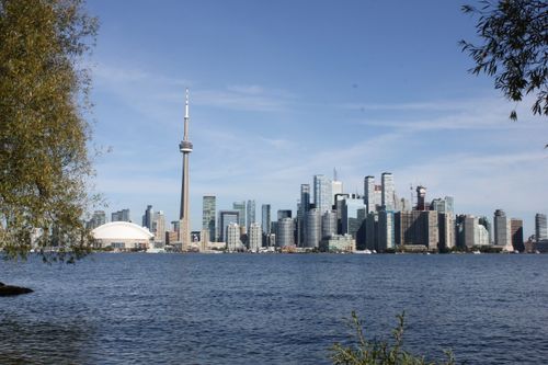 Free Scenic view of Toronto skyline featuring the iconic CN Tower across Lake Ontario on a clear day. Stock Photo