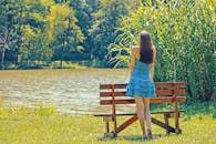 妇女在湖边享受一个和平的时刻，在夏天拥抱自然