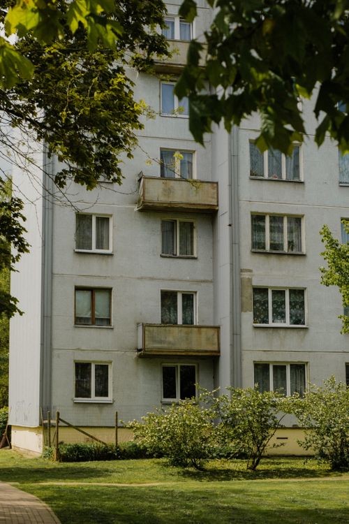 Free A residential apartment building with balconies, surrounded by greenery and trees. Stock Photo