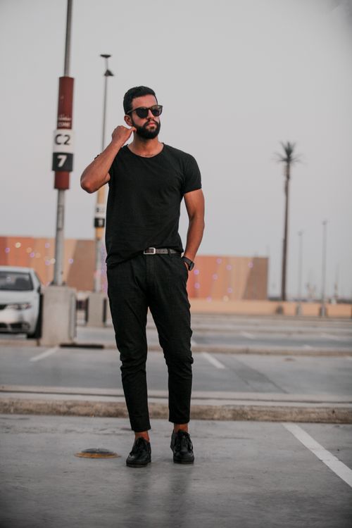 Free Fashionable man in all-black outfit posing confidently in an urban outdoor setting. Stock Photo