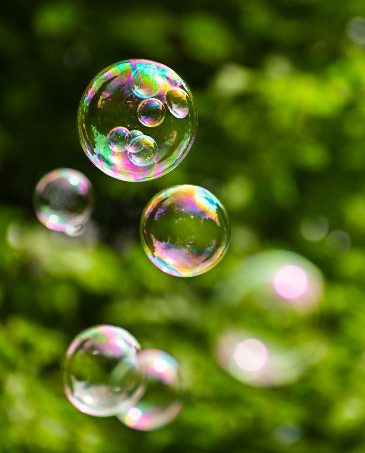Colorful soap bubbles floating in sunlight, symbolizing the fragility of positive thinking without practical structure behind it