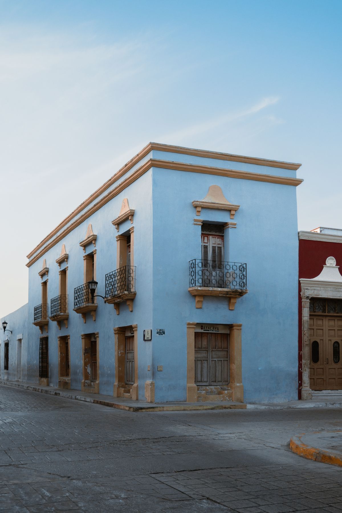 Elegant colonial building with bright blue facade in San Francisco de Campeche, Mexico.