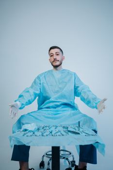 Surgeon in blue scrubs with surgical instruments ready for operation.