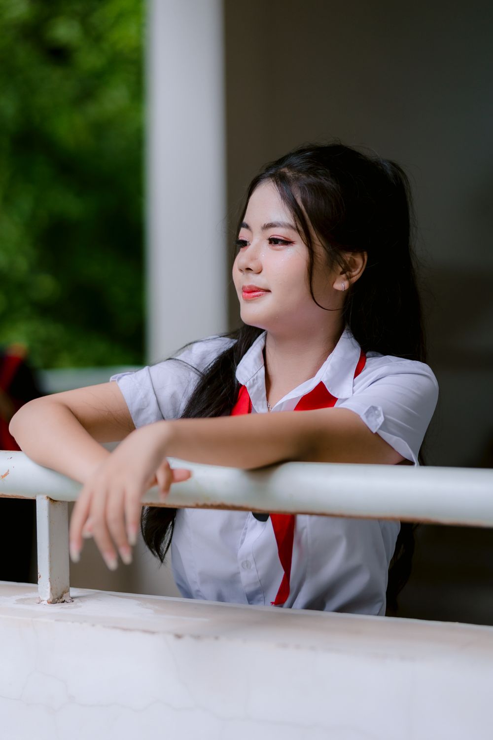 Young Woman in Uniform Leaning on Railing · Free Stock Photo