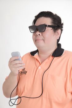 Adult man wearing sunglasses and a polo shirt, holding a device with a wire attached.