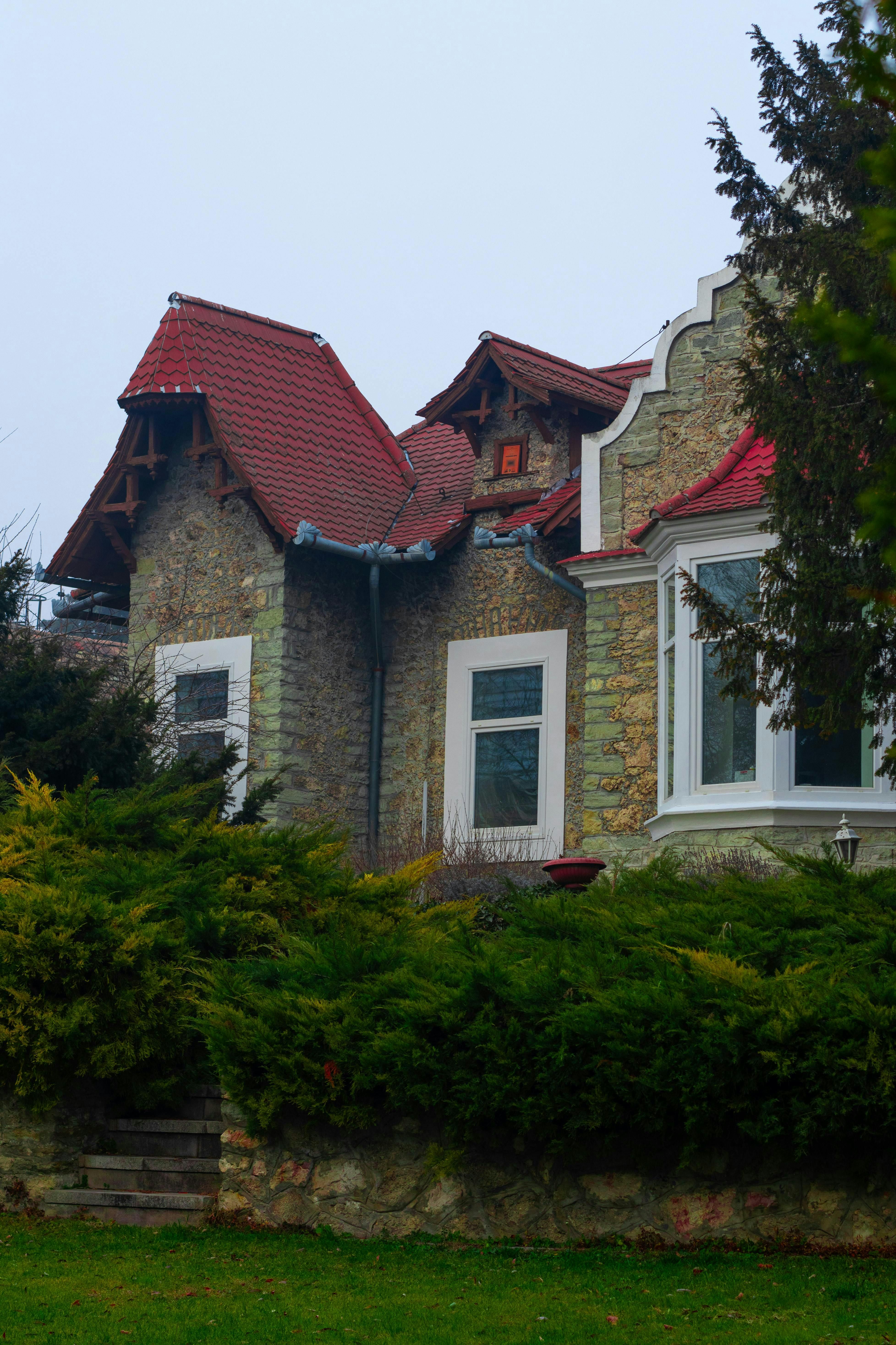 Charming Stone House with Red Roof in Lush Setting · Free Stock Photo