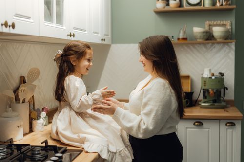 Free A warm mother-daughter moment captured in a vintage kitchen setting. Stock Photo