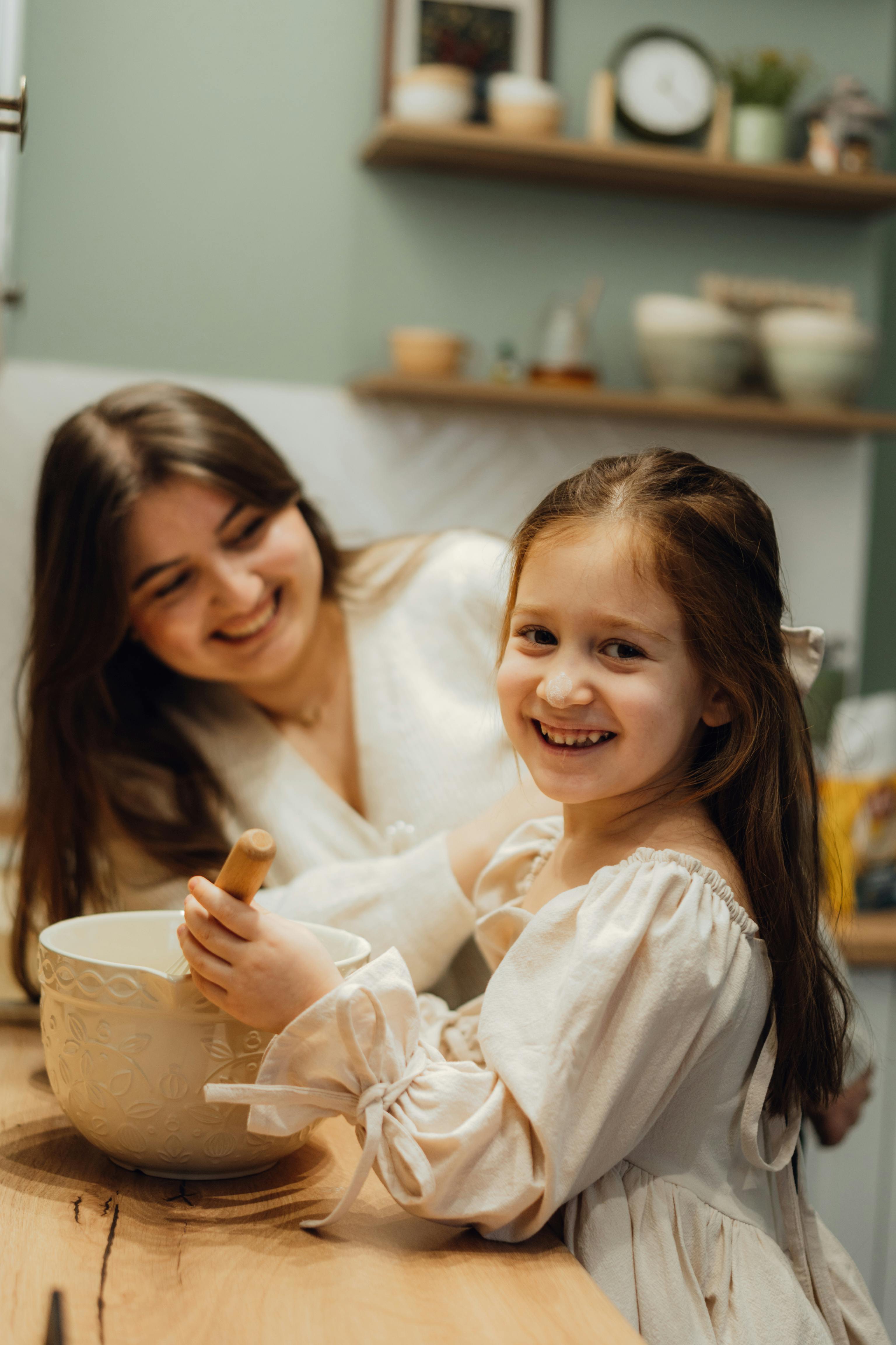 A joyful mother and daughter baking in a warm, cozy kitchen setting, sharing special moments.