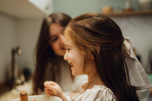Free A mother and daughter bonding in the kitchen, enjoying a fun baking session. Stock Photo