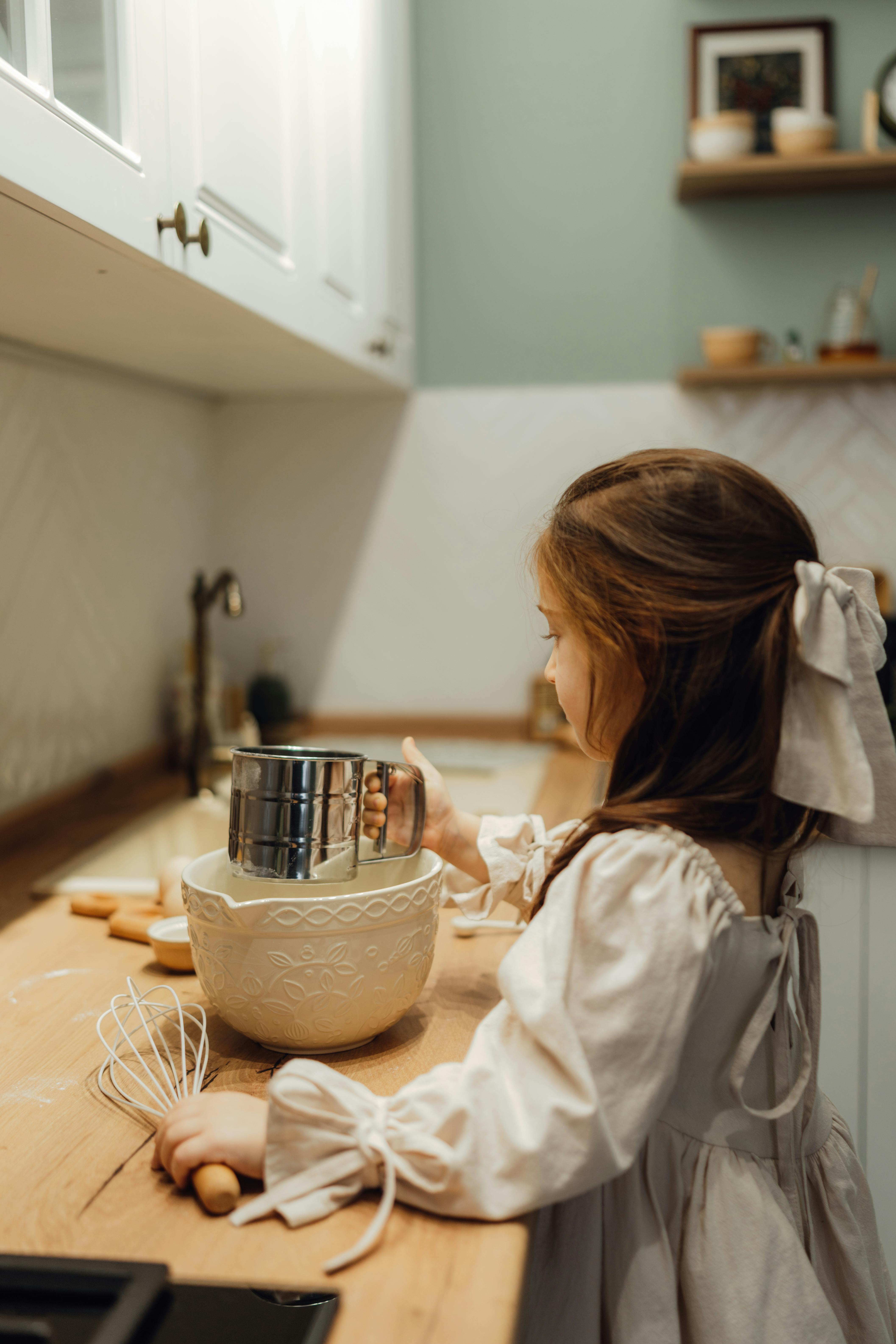 A young girl baking in a cozy kitchen, showcasing childhood creativity and home lifestyle.