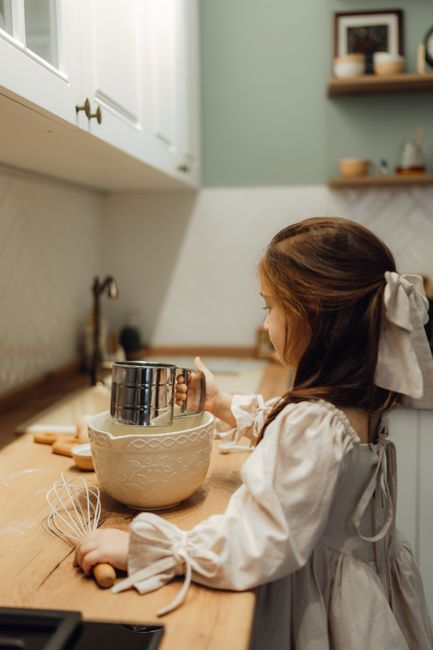 A young girl baking in a cozy kitchen, showcasing childhood creativity and home lifestyle.