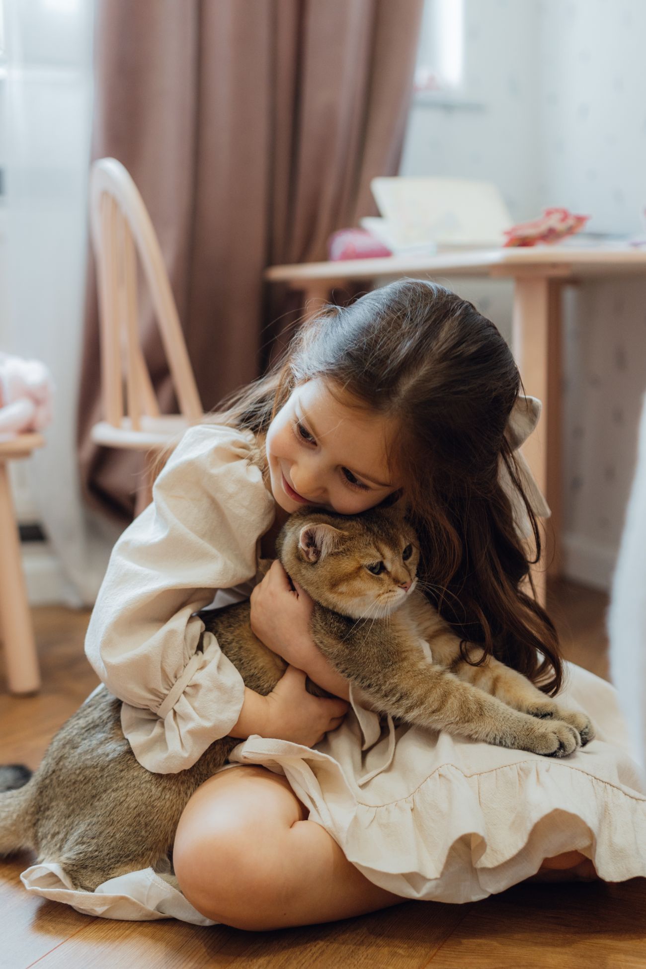 室内で子どもが猫を抱きしめている様子
