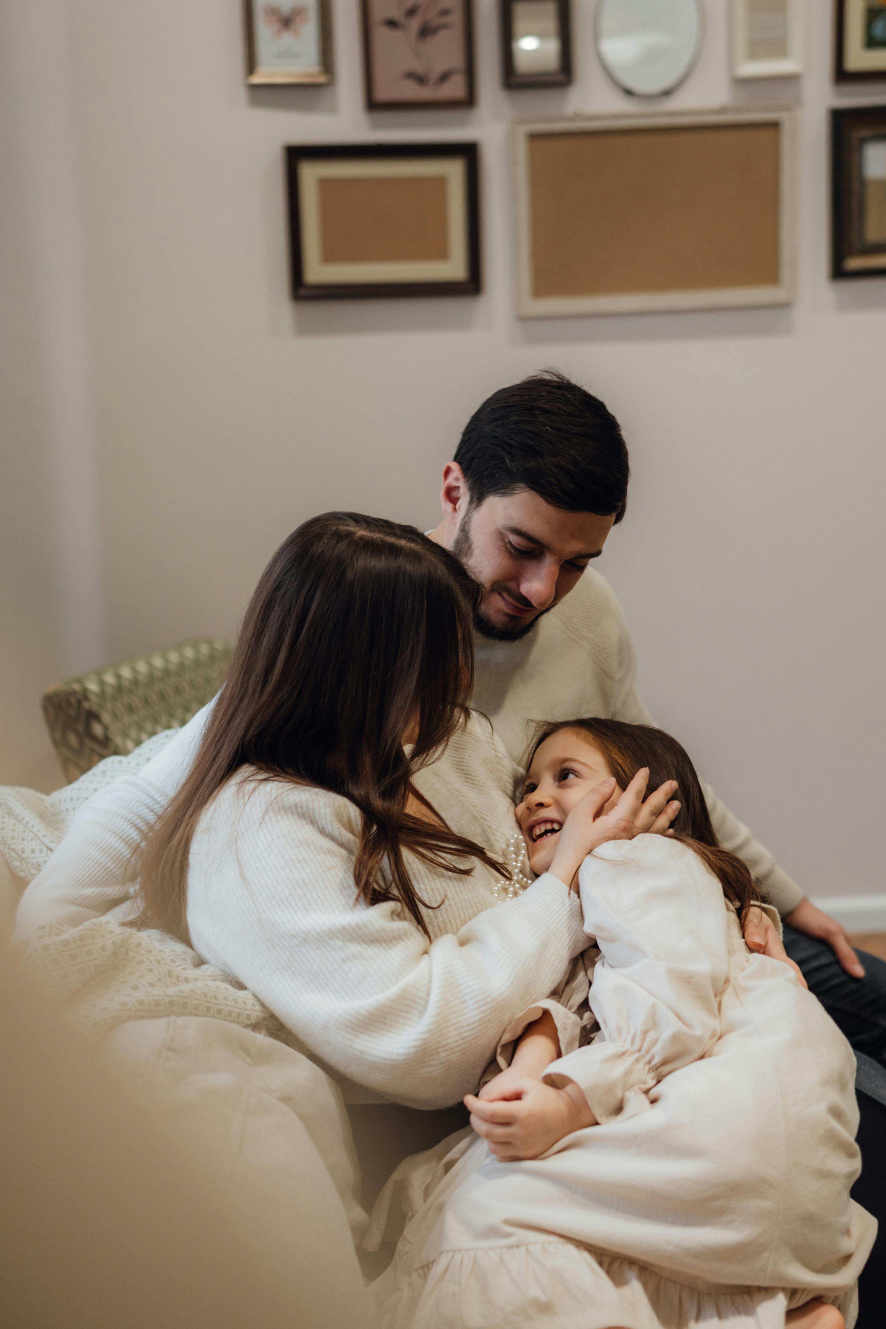 A family enjoying a tender and affectionate moment together indoors, captured in warm tones.