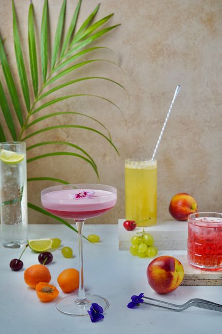Vibrant summer cocktails with fresh fruits and palm leaves creating a tropical vibe.