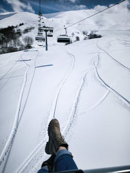View from a ski lift over fresh snowy tracks, perfect for winter adventures.