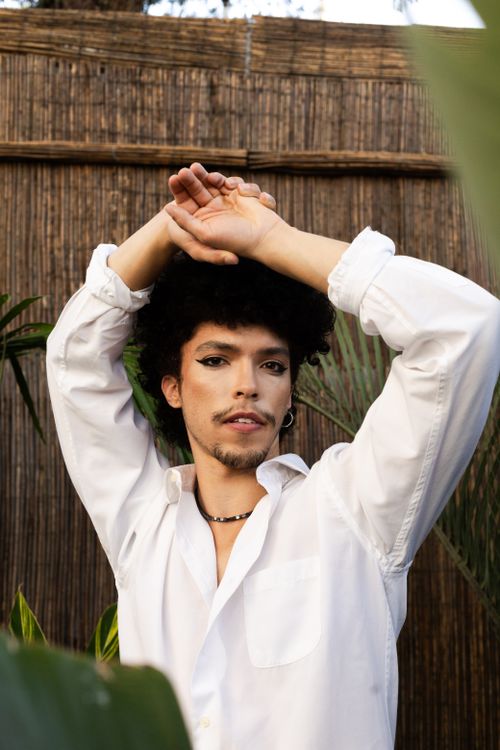 Free Captivating portrait of a styled young adult with bold makeup and natural hair in an outdoor setting. Stock Photo