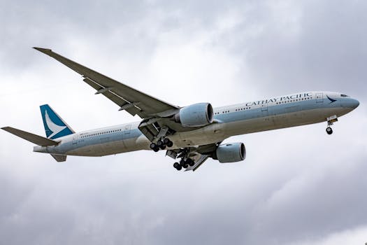Cathay Pacific aircraft landing at Los Angeles International Airport under cloudy skies.