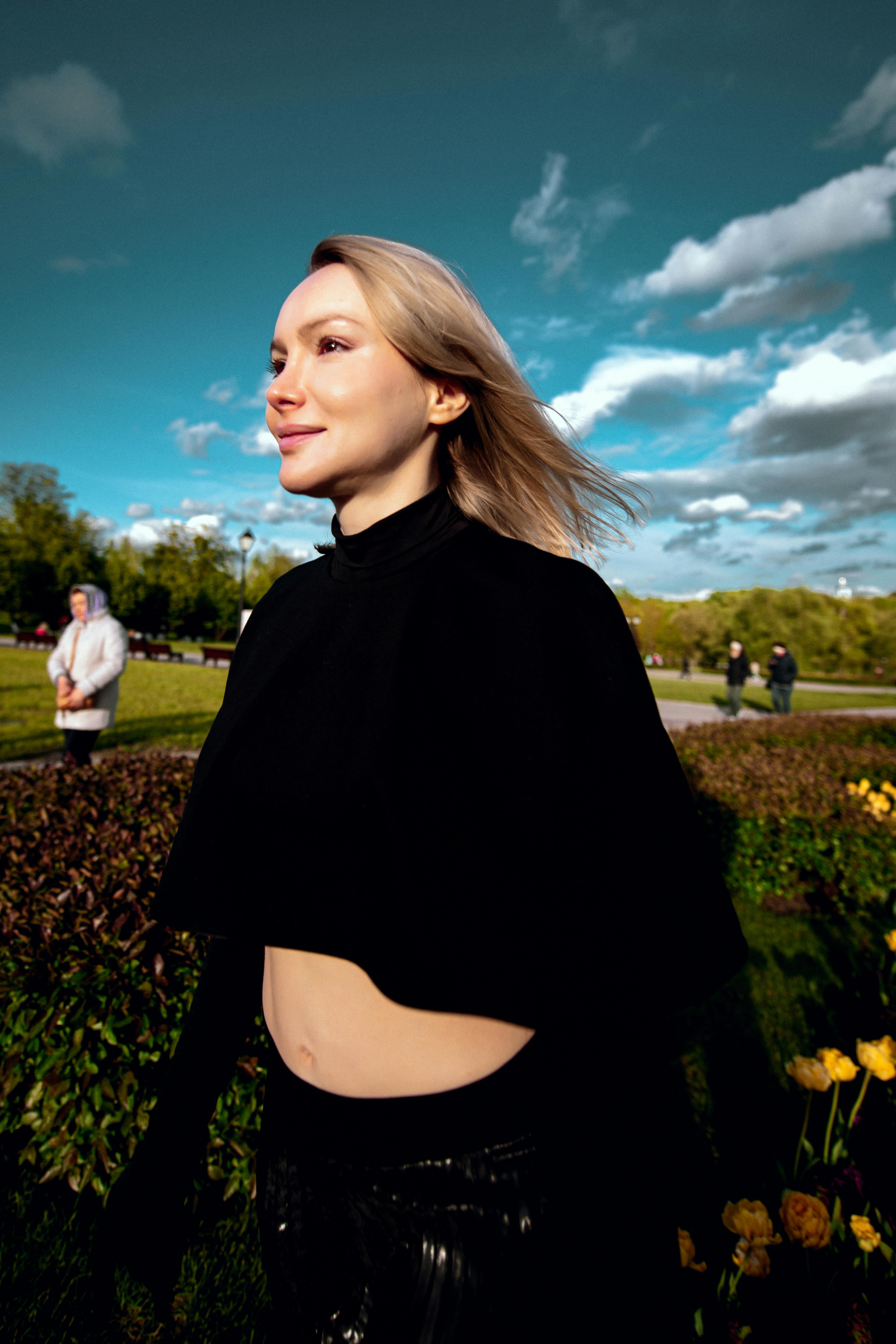 бесплатная Уверенная в себе женщина прогуливается по солнечному парку Стоковое фото