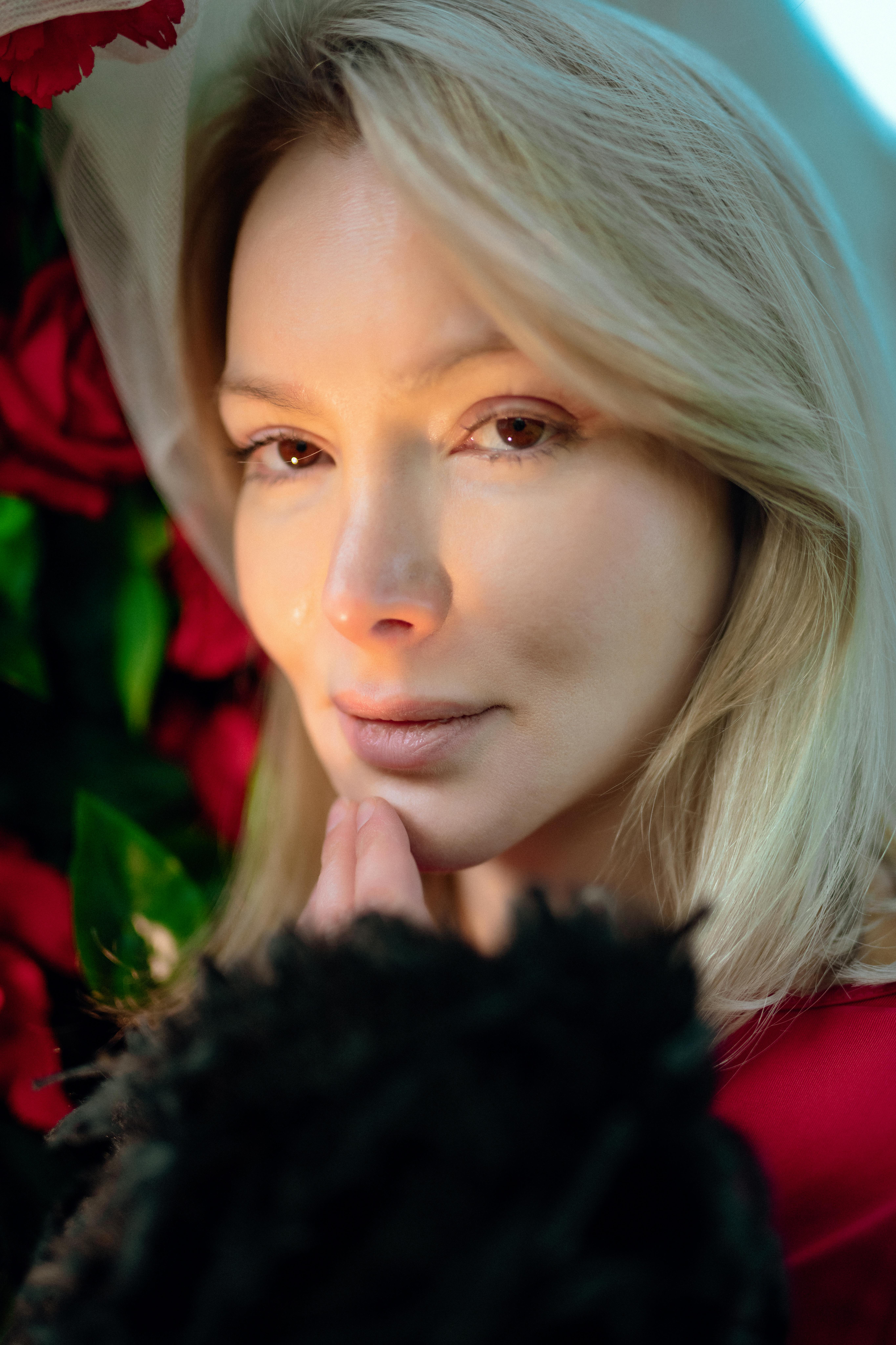 Kostnadsfria Närbildporträtt av en kvinna med rosor, som förmedlar värme och elegans. Stock foto