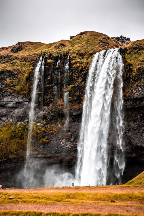 бесплатная Водопады на коричневой скалистой горе Стоковое фото