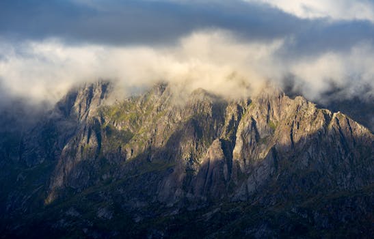 Majestic Lofoten mountain landscape draped in dramatic clouds at sunset.