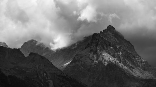 Moody black-and-white photo of rugged mountains and dramatic clouds at Gap, France.
