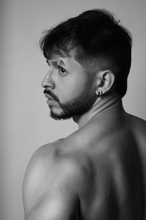 Free Artistic black and white portrait of a man looking over his shoulder with a focused expression. Stock Photo