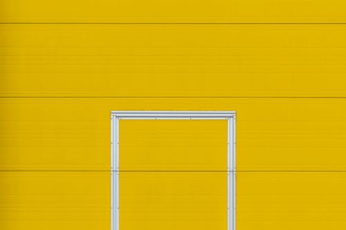 Free Minimalistic design featuring a bright yellow wall and a metal frame, perfect for creative projects. Stock Photo
