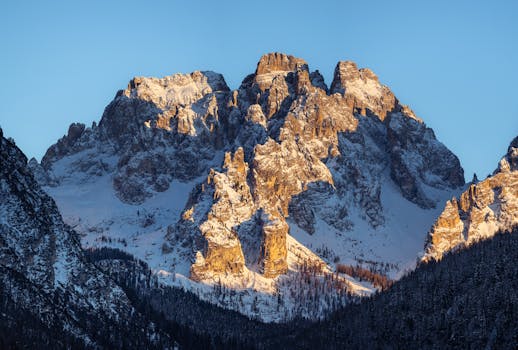 A breathtaking view of the snow-covered Dolomites in Italy, illuminated by the warm glow of sunset.