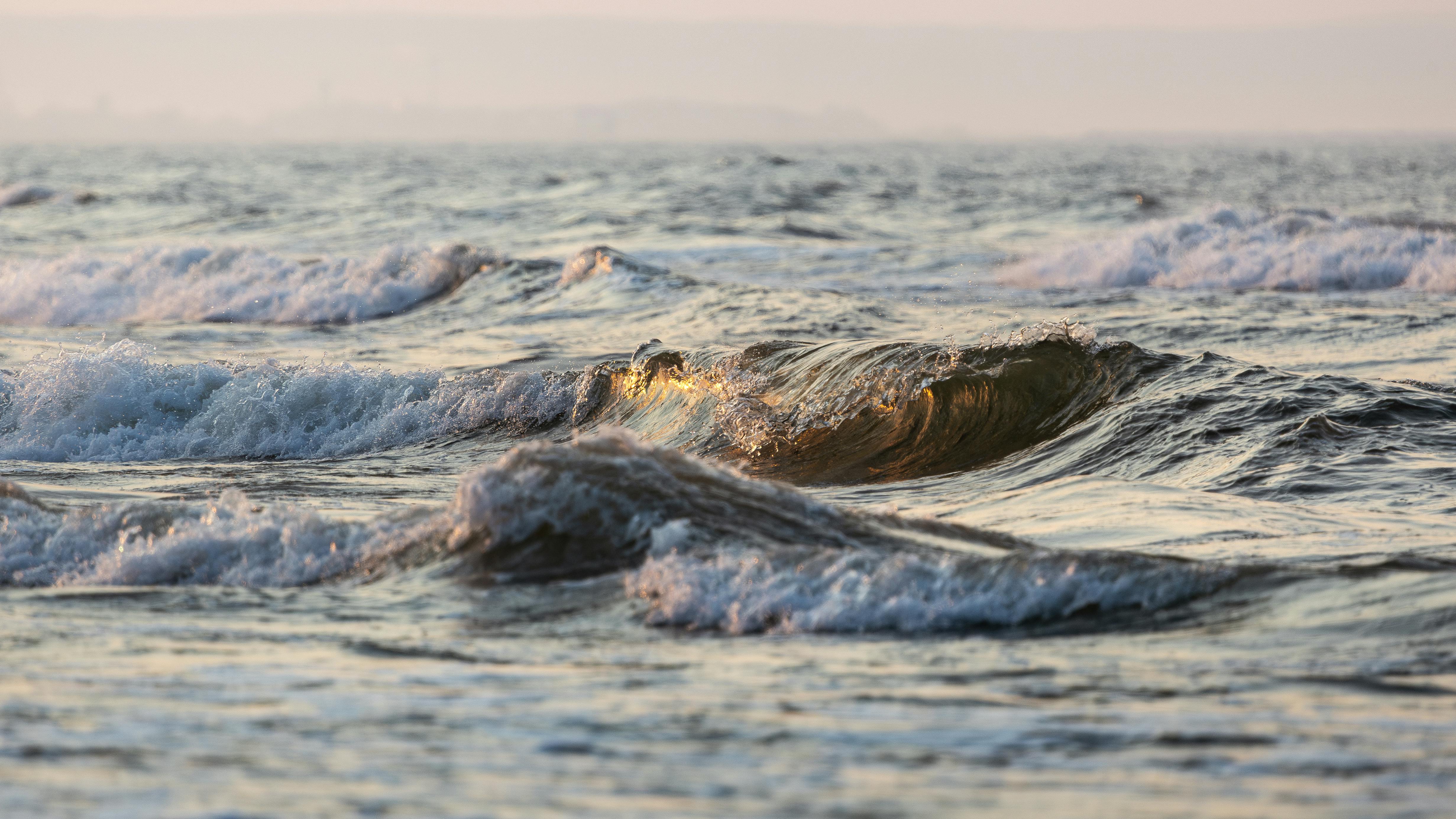 Tranquil waves rolling in the Baltic Sea during sunset, capturing the peaceful seaside ambiance.