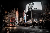 伦敦皮卡迪利广场的夜晚充满活力，双层巴士和发光广告牌点亮了这里的城市生活