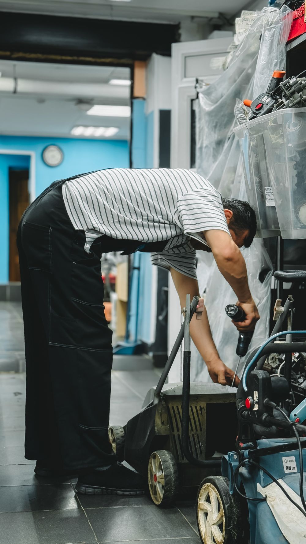 Técnico reparando una podadora en el taller