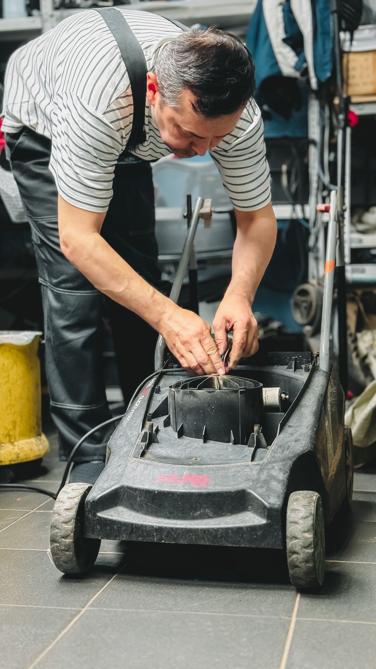 Repairing a lawn mower in a garage workshop