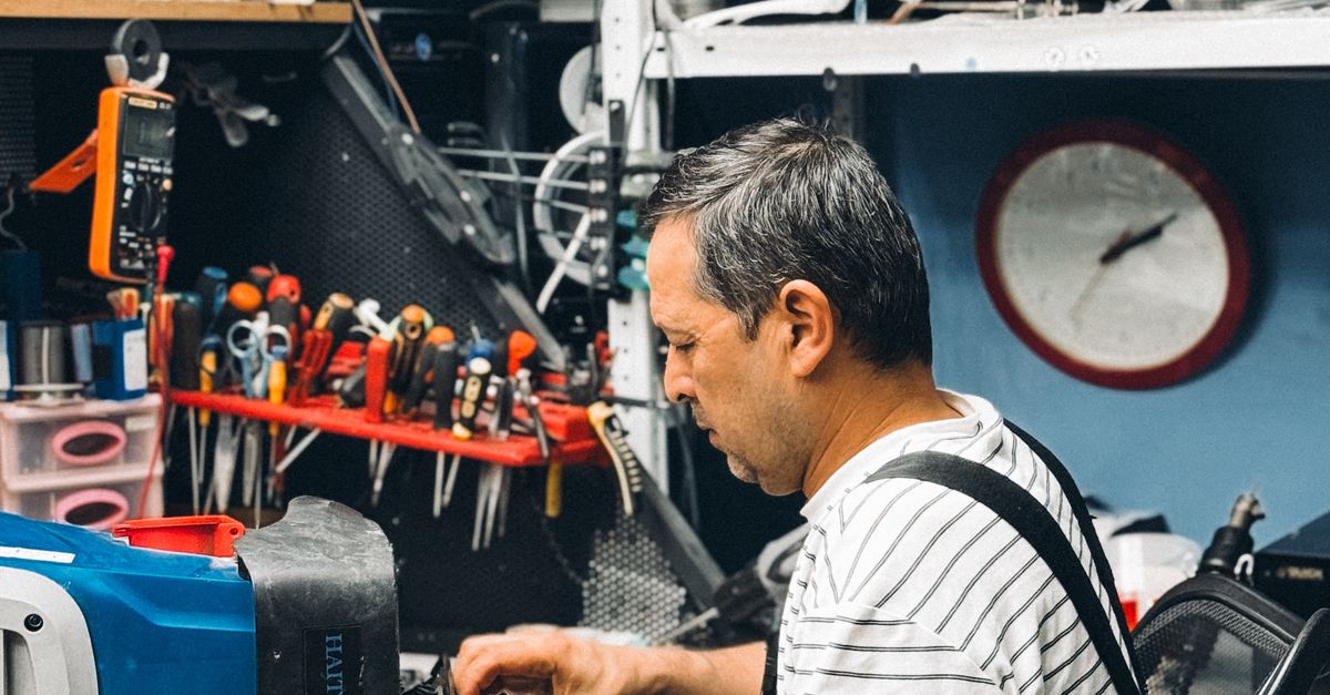 Técnico focado trabalhando com eletrônicos, representando inovação em pequenas empresas